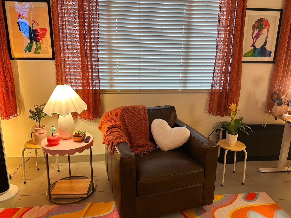 The therapy room — a cozy leather chair beside a scalloped lamp and plants